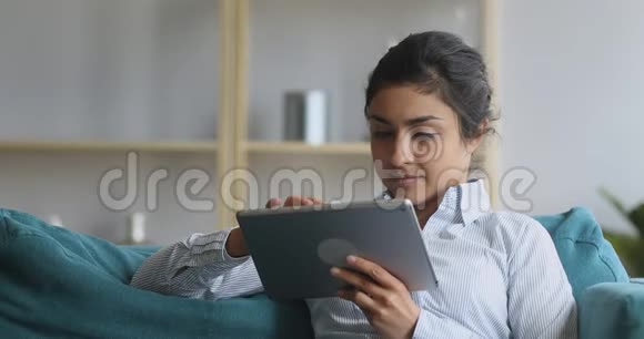 印度妇女使用数码平板电脑在家中放松视频的预览图
