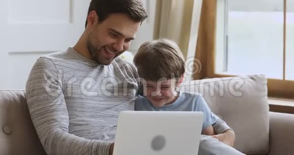 开心地笑着和爸爸在电脑上玩游戏视频的预览图
