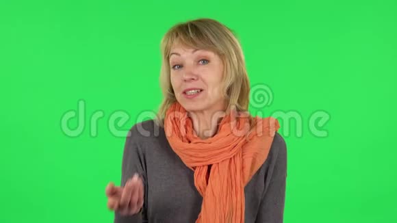 中年金发女人的肖像正在谈论什么然后做一个安静的手势秘密绿色屏幕视频的预览图