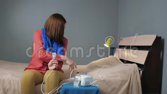 女孩螺丝吸入面罩到喷雾器穿着红色衬衫和蓝色毛巾的年轻女子独自坐在房间里系紧视频的预览图
