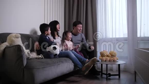 快乐的中国家庭在电视上观看足球比赛视频的预览图