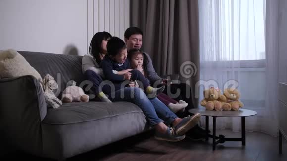 友好的亚洲家庭在客厅看电视视频的预览图