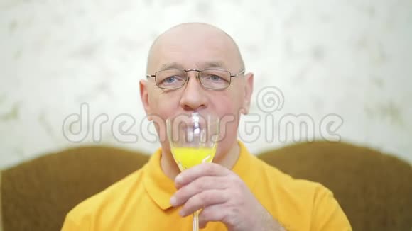 微笑的男人从杯子里喝水果鸡尾酒视频的预览图