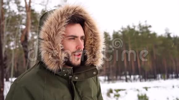 迷人的留着胡子的人站在冬季森林的户外视频的预览图