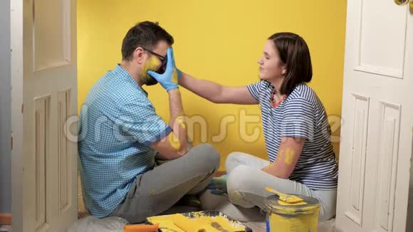 疲惫的夫妻正坐在地板上男人高兴地哭着女孩试图让他平静下来油漆修理视频的预览图