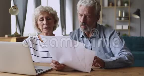 在家管理家庭预算的严肃的老夫妇视频的预览图