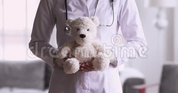 女子儿科医生拿着玩具熊玩具近距离观看视频的预览图