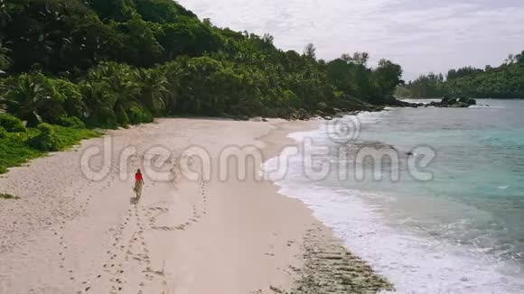 天堂上的年轻女子安斯巴扎卡海滩背光美丽的马河岛上晒黑的女孩的空中镜头旅费视频的预览图