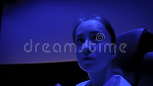 女人的脸看着电影院周围的蓝光照明视频的预览图