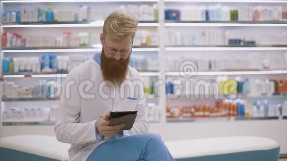 药剂师在触摸屏上用手指滚动平板电脑视频的预览图