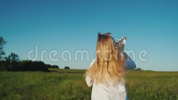 一个留着长发的女孩手里拿着纸飞机跑步婴儿梦的概念后视图视频的预览图