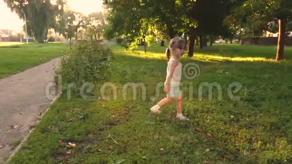 春天婴儿在公园里玩耍慢动作夏天孩子在草坪上玩快乐的孩子在夏天的草地上奔跑视频的预览图