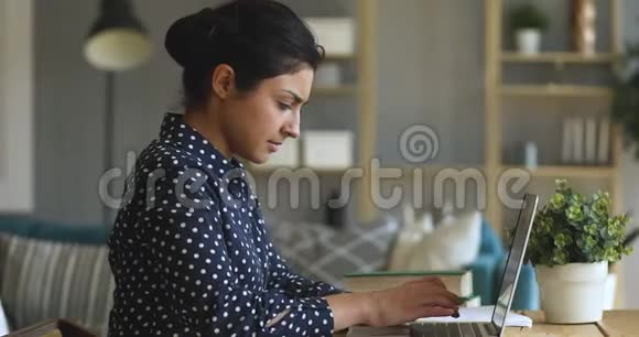 专注于在家学习笔记本电脑的印度年轻女生视频的预览图