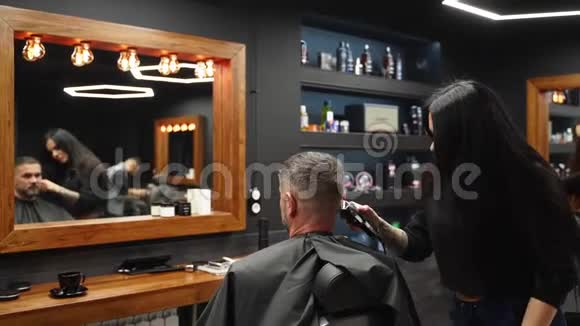 理发店的女理发师用理发刀给留胡子的男人理发男士发式及沙龙理发梳毛视频的预览图