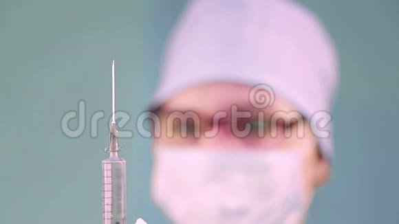 戴着医用口罩的女医生手里拿着注射器从注射器转移焦点到面部视频的预览图