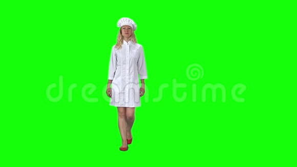 金发厨师穿着白色制服戴着顶绿色屏幕的帽子慢动作视频的预览图