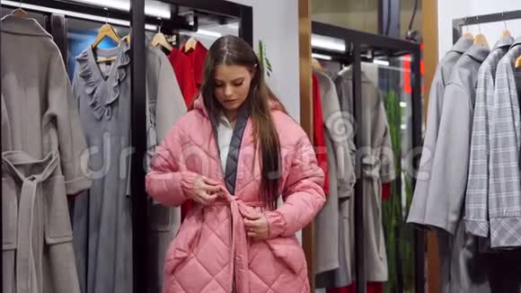 一位白种人妇女在一家时尚精品店里选择秋季季节购买的衣服视频的预览图