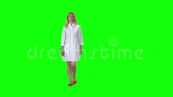 一个金发女孩穿着白色的医疗外套对着绿色的屏幕慢动作视频的预览图