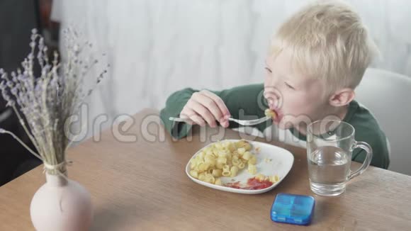 男孩在家吃意大利面午餐时吃肉球视频的预览图
