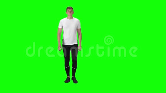 穿着白色t恤运动裤和运动鞋的年轻人背景是绿色慢动作视频的预览图