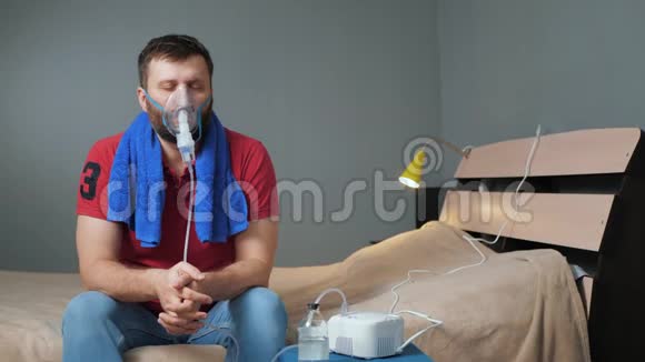 人用雾化器吸入年轻人独自坐在房间里脸上戴着吸入面罩视频的预览图