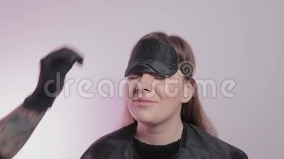 专业的女眉大师在一家美容院把眉毛上的胶卷放在眉毛上视频的预览图