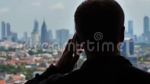 男人在城市的背景下打电话视频的预览图