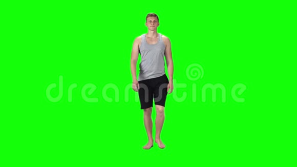 一个穿着灰色单品和短裤背景是绿色的年轻人慢动作视频的预览图