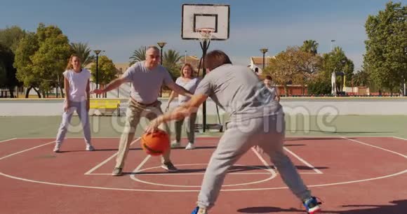 家庭篮球运动员在操场上练习攻击对手拥有球改变领导地位视频的预览图
