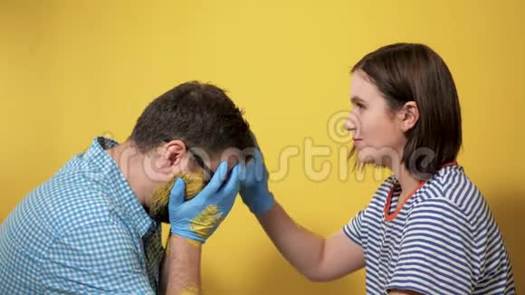 男人高兴地哭着画墙女孩试图通过抚摸他的头来安抚他油漆修理工作结束视频的预览图