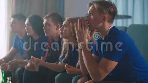 情绪球迷在电视上兴奋地观看足球比赛然后为胜利坐在沙发上而欢欣鼓舞视频的预览图