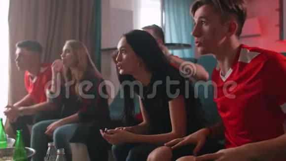 两个女朋友和三个男朋友在家看电视他们最喜欢的球队获胜球队很高兴大声喊叫视频的预览图