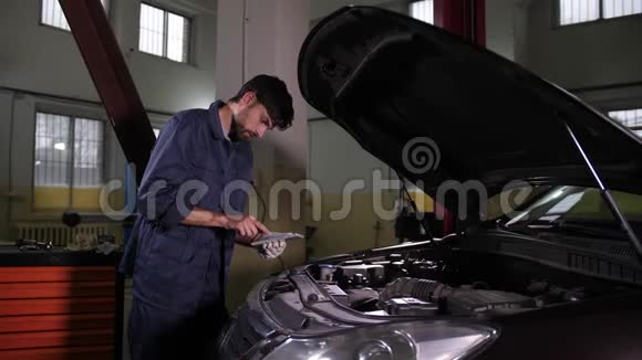 使用平板电脑寻找备件的汽车修理工视频的预览图