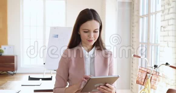 快乐的千禧年职业女商人使用数字平板电脑视频的预览图