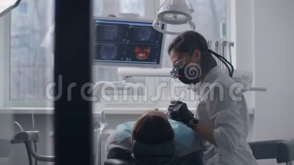 女牙医和病人一起工作媒体女牙医用专业牙齿检查及治疗病人牙齿视频的预览图