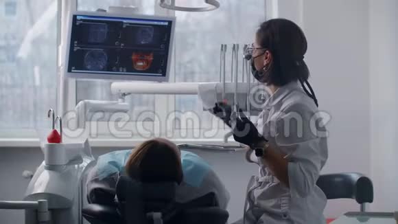 一位女牙医打开灯开始和病人一起工作现代牙科诊所视频的预览图
