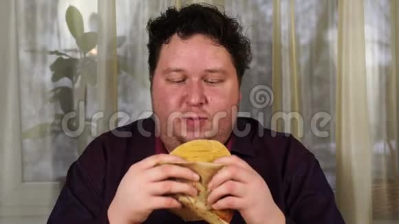 年轻人咬三明治胖子吃快餐很饿的家伙视频的预览图