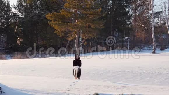 冬天森林里的女人玩雪扔雪花视频的预览图