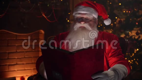 欢乐的正宗圣诞老人条款翻页红色封面书壁炉和圣诞树上视频的预览图