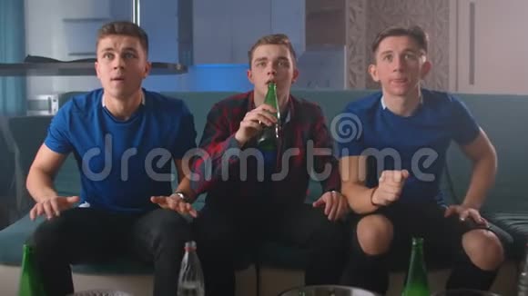 看着镜头三个朋友看着一场运动比赛他们穿着蓝色t恤更担心跳起来视频的预览图
