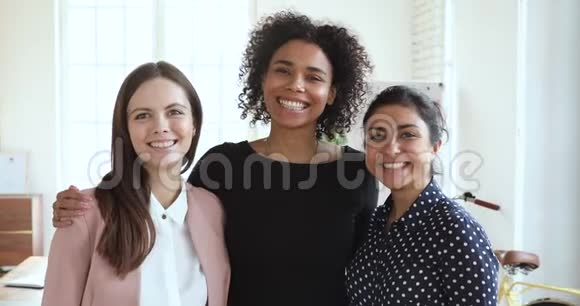 三位快乐友好的不同种族女性在室内拥抱亲密关系视频的预览图