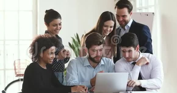快乐的多种族商业团队使用笔记本电脑讨论数字项目视频的预览图
