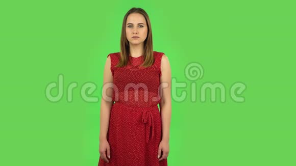 穿着红色衣服的温柔女孩无动于衷地拍手绿色屏幕视频的预览图