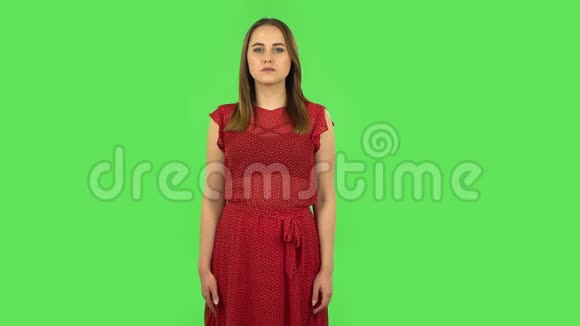 穿红色衣服的温柔女孩在做白日梦微笑着抬头看绿色屏幕视频的预览图