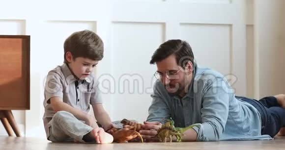 爱爸爸和学龄前儿童在家玩恐龙视频的预览图