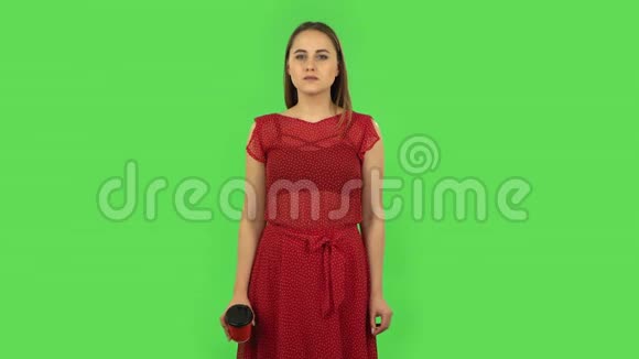 穿红色裙子的温柔女孩正在享受咖啡绿色屏幕视频的预览图