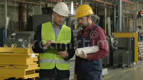 两个戴着安全帽的人在工厂车间工作视频的预览图