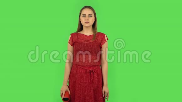 穿着红色裙子的温柔女孩正在用蓝牙便携式扬声器和舞蹈听音乐绿色屏幕视频的预览图