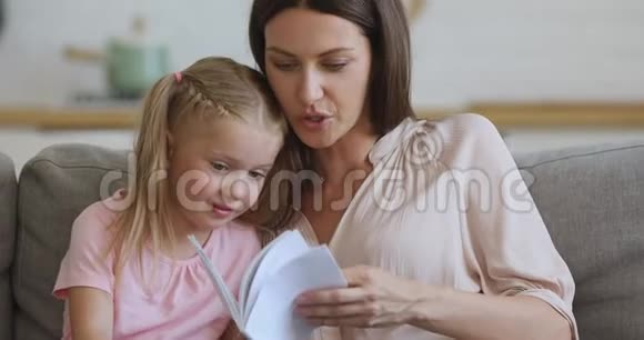 专注的年轻母亲给女儿读有趣的故事视频的预览图