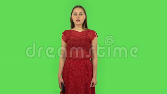 穿着红色衣服的温柔女孩在为移动而说话震惊然后高兴绿色屏幕视频的预览图